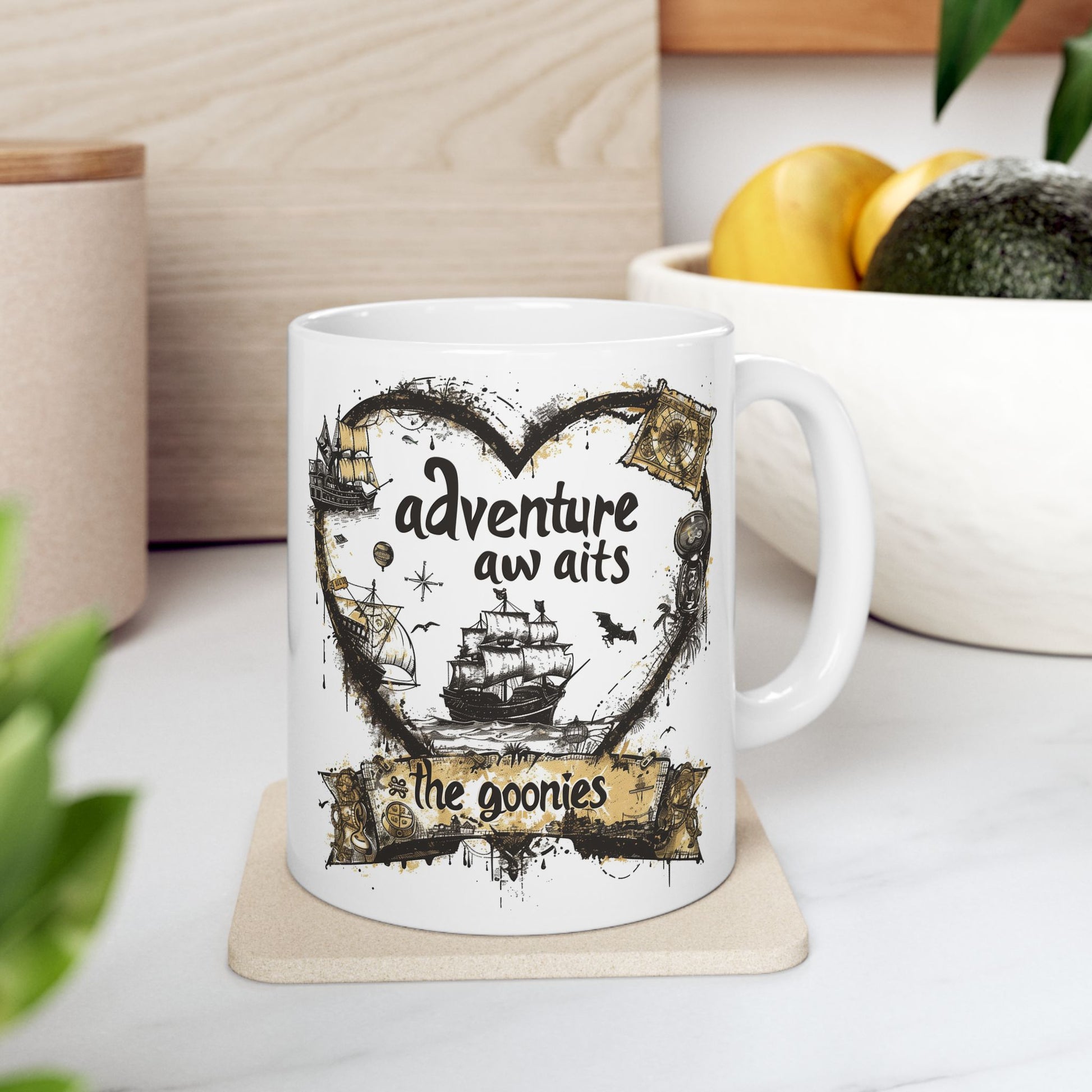 White mug with 'adventure awaits' design on a coaster, surrounded by plants and a bowl of fruit.