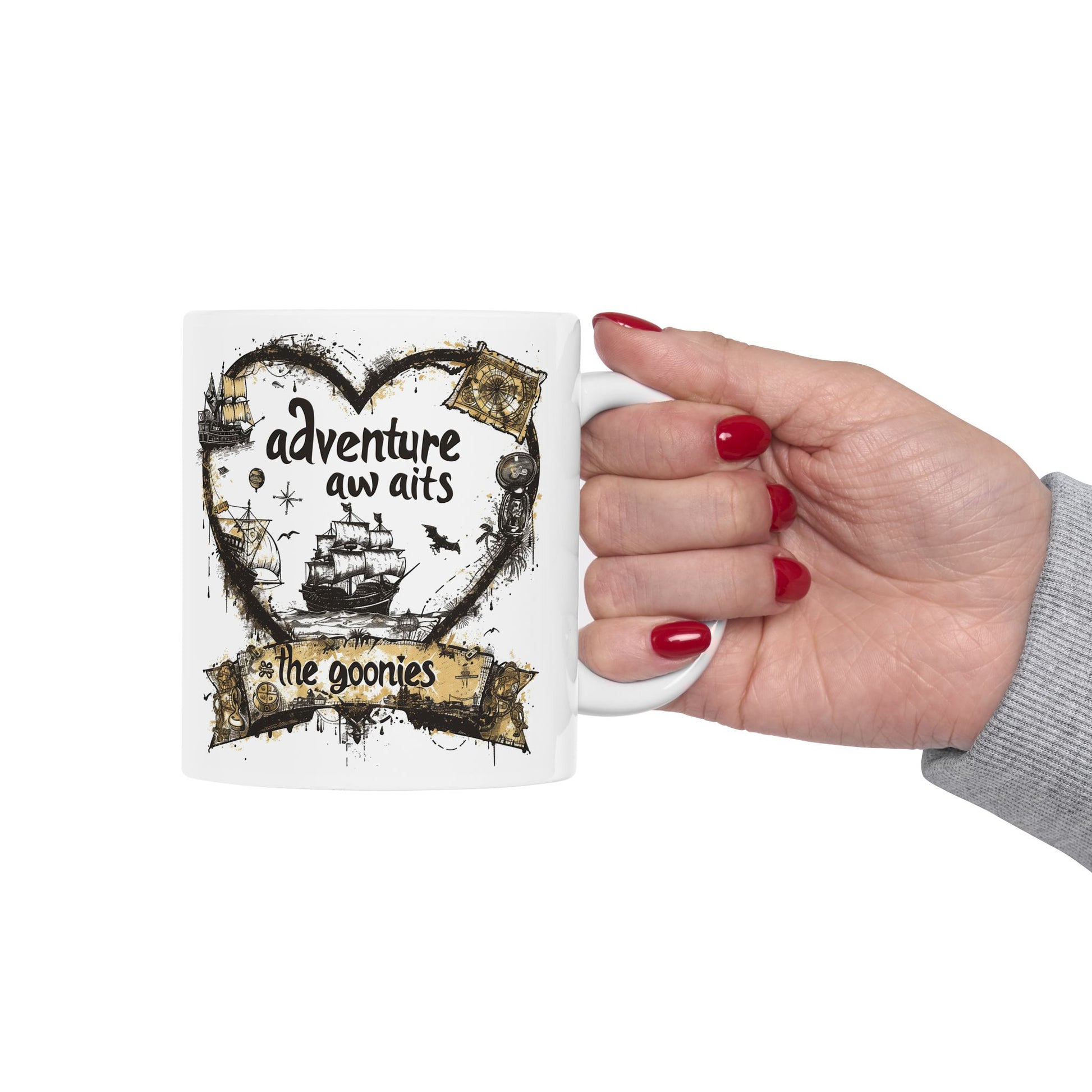 Mug with 'adventure awaits' design held by a hand with red nail polish on a white background